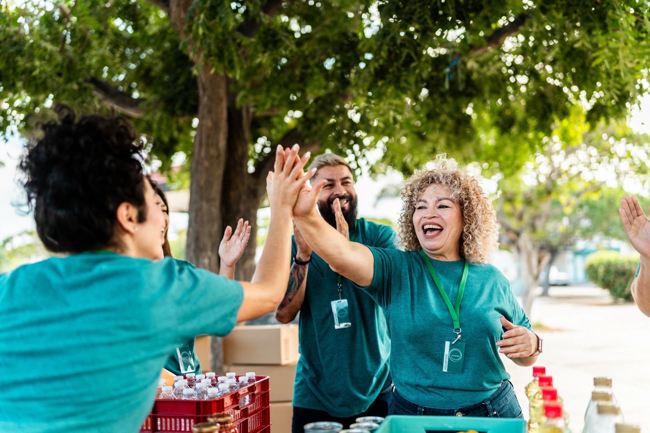 Volunteers organizing donation boxes outdoors and celebrating teamwork