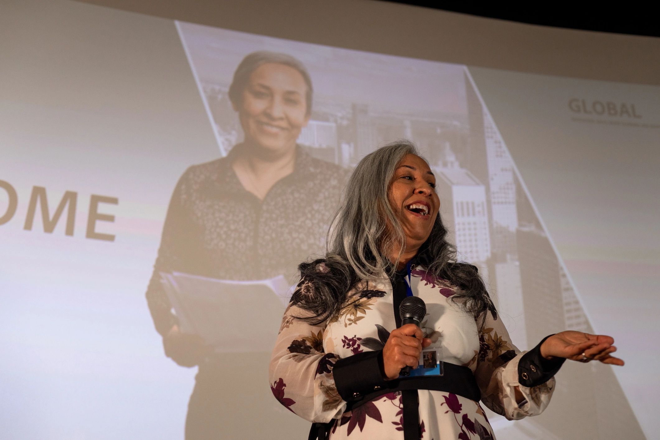 Female speaker addressing an audience on stage